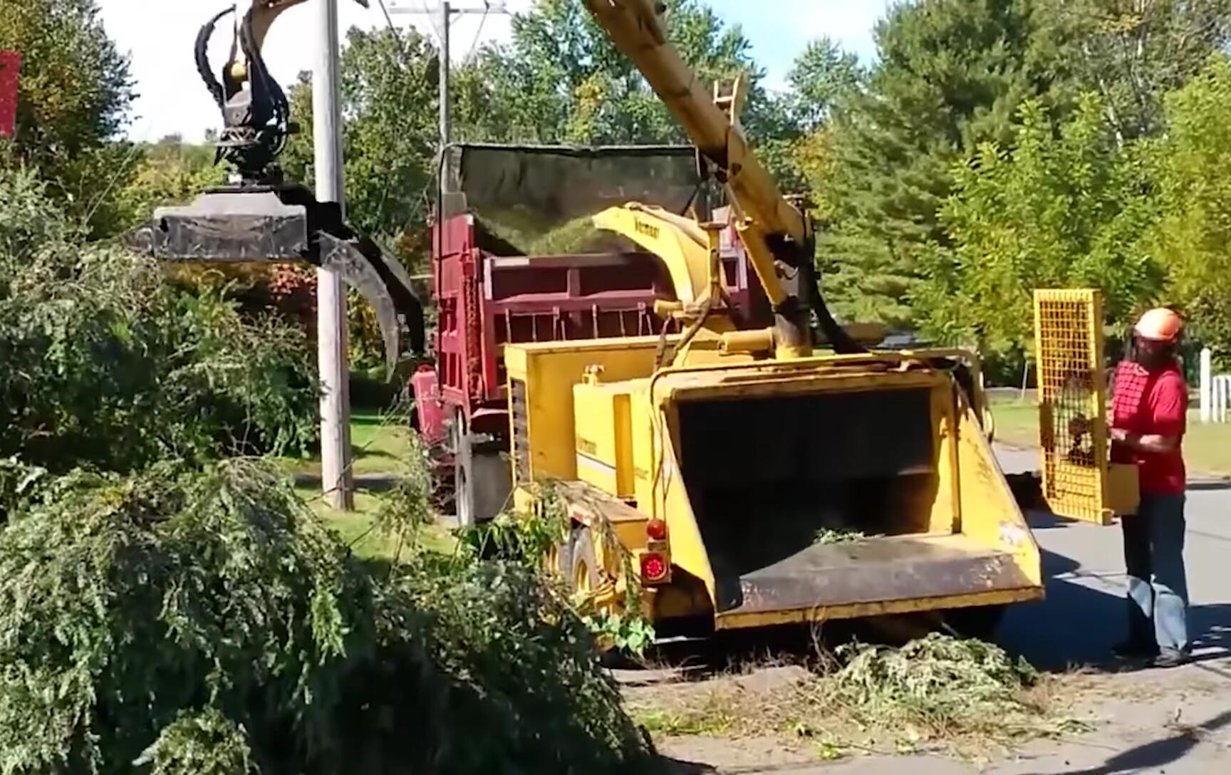 Large Vermeer wood chipper and log loader working together.
