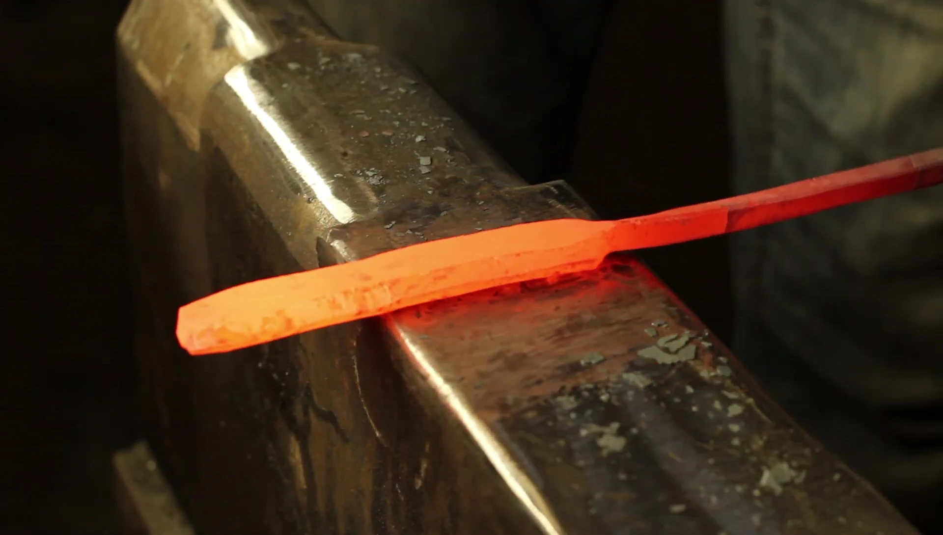 The smith demonstrates the creation of a hollow in the spatula head to reduce anvil contact.
