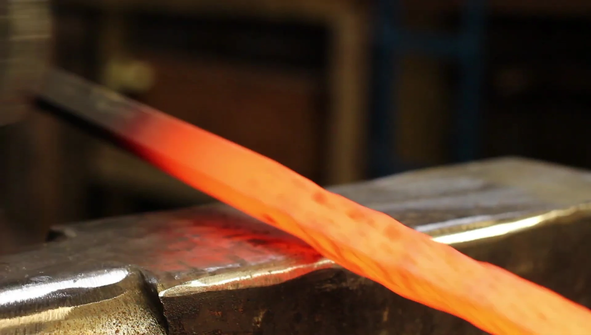 The smith carefully shapes the metal using a half-on, half-off hammering technique.