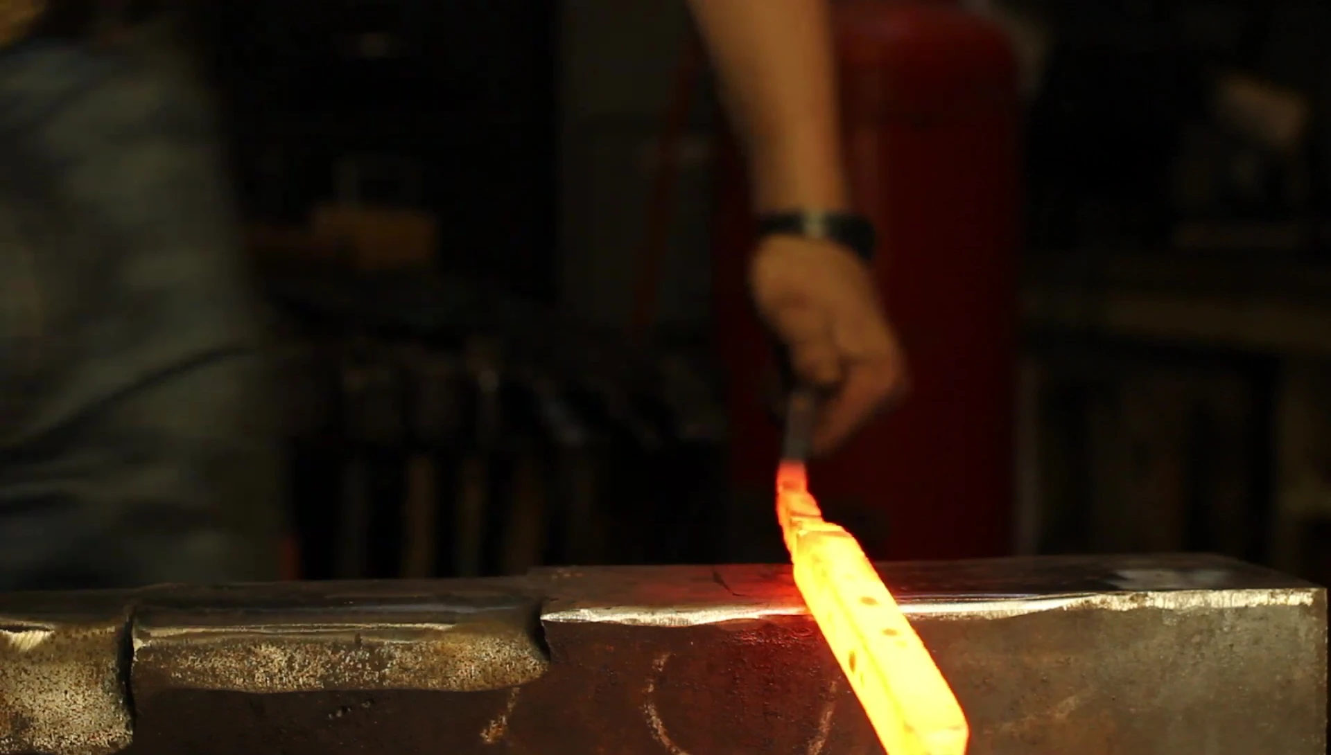 The smith creates the shoulder of the spatula, leaving a section of the square bar for the handle.