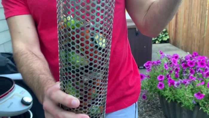 Place the grilling baskets on the grill using the built-in stands. Insert the basket handles into the grill grates' holes.