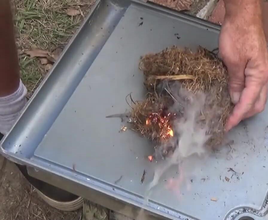 Chimney starter placed on top of burning material.