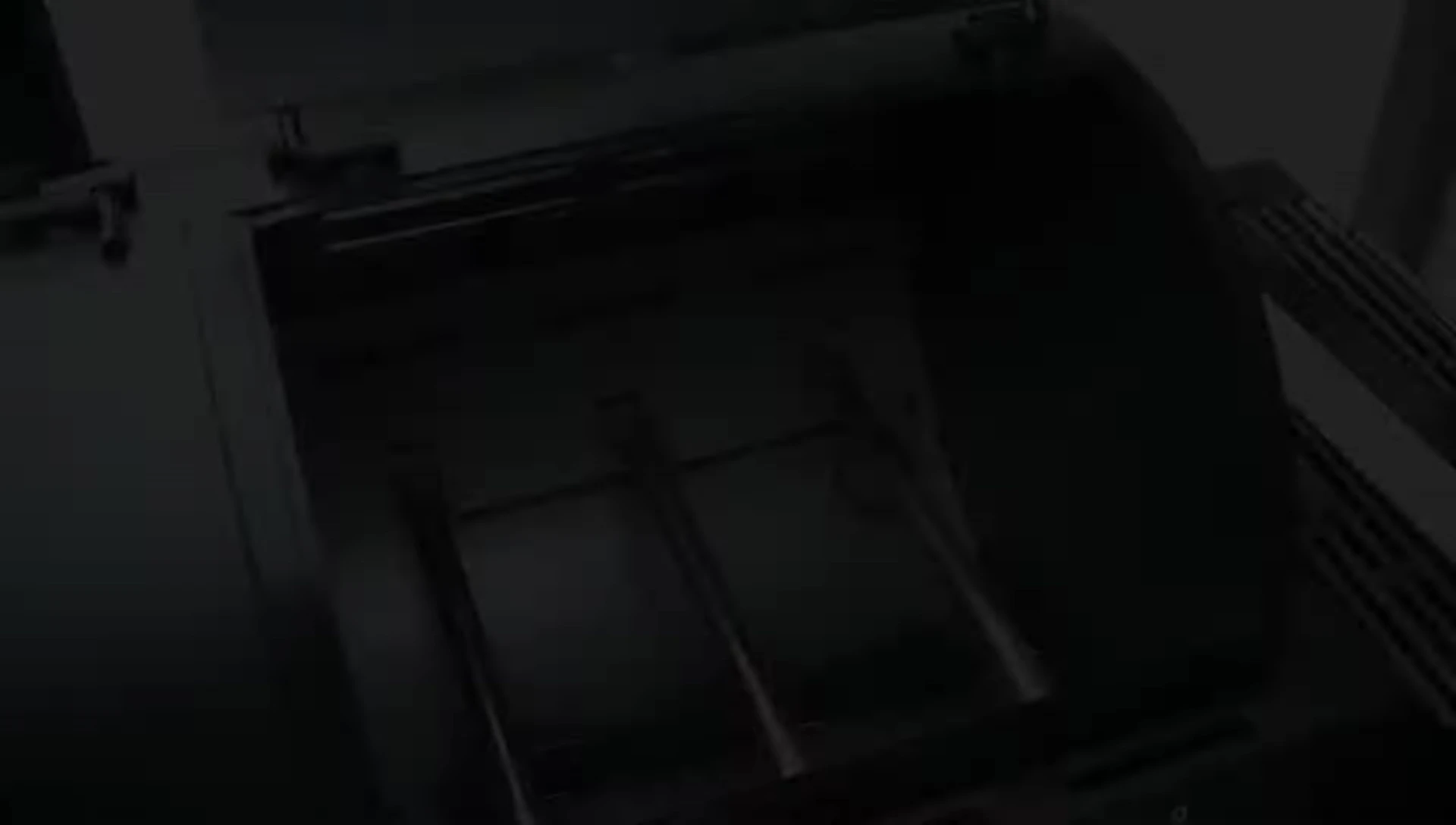 The presenter points at the gas section of the grill