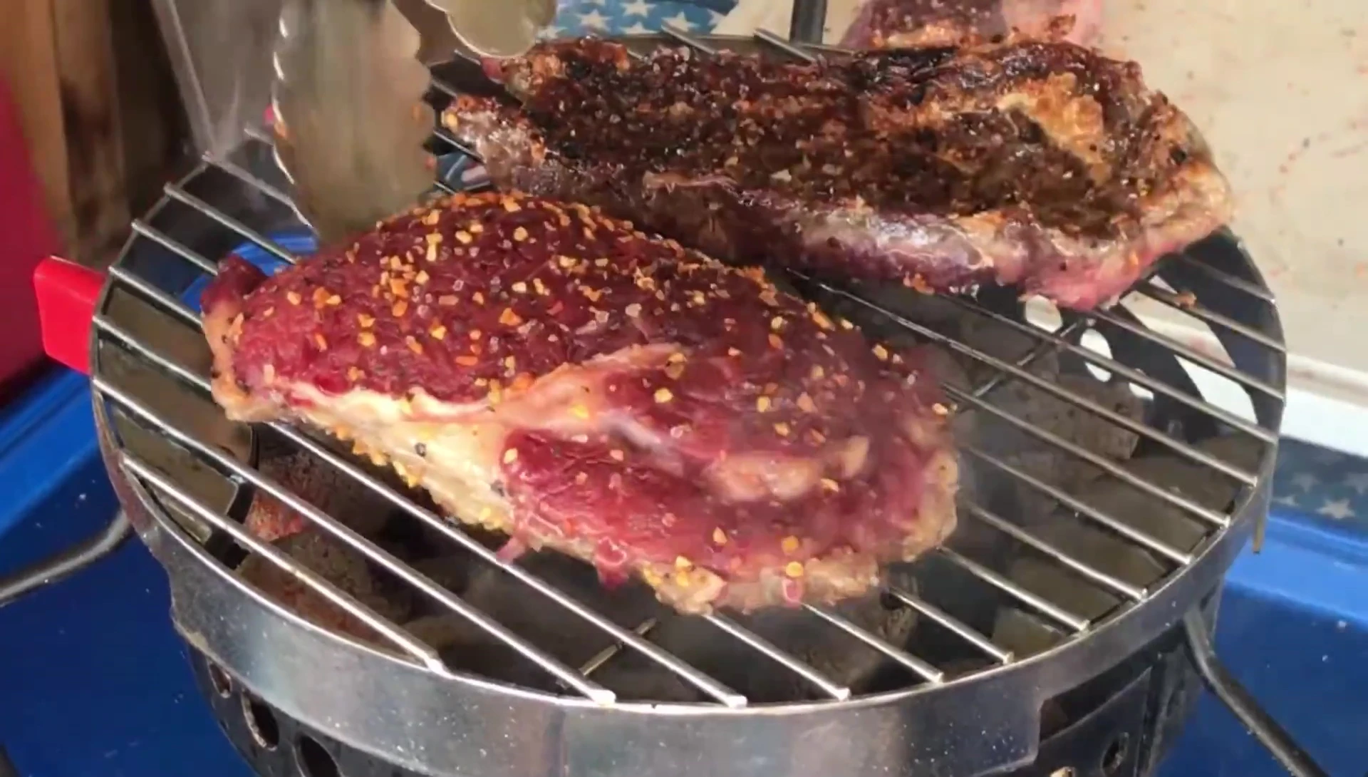 Flipping the ribeye steaks.