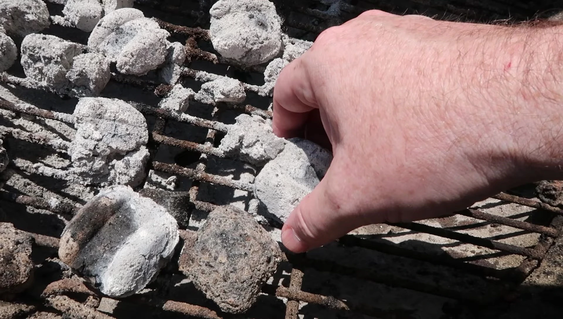 Close-up of the partially burned briquettes, showcasing their reusability.
