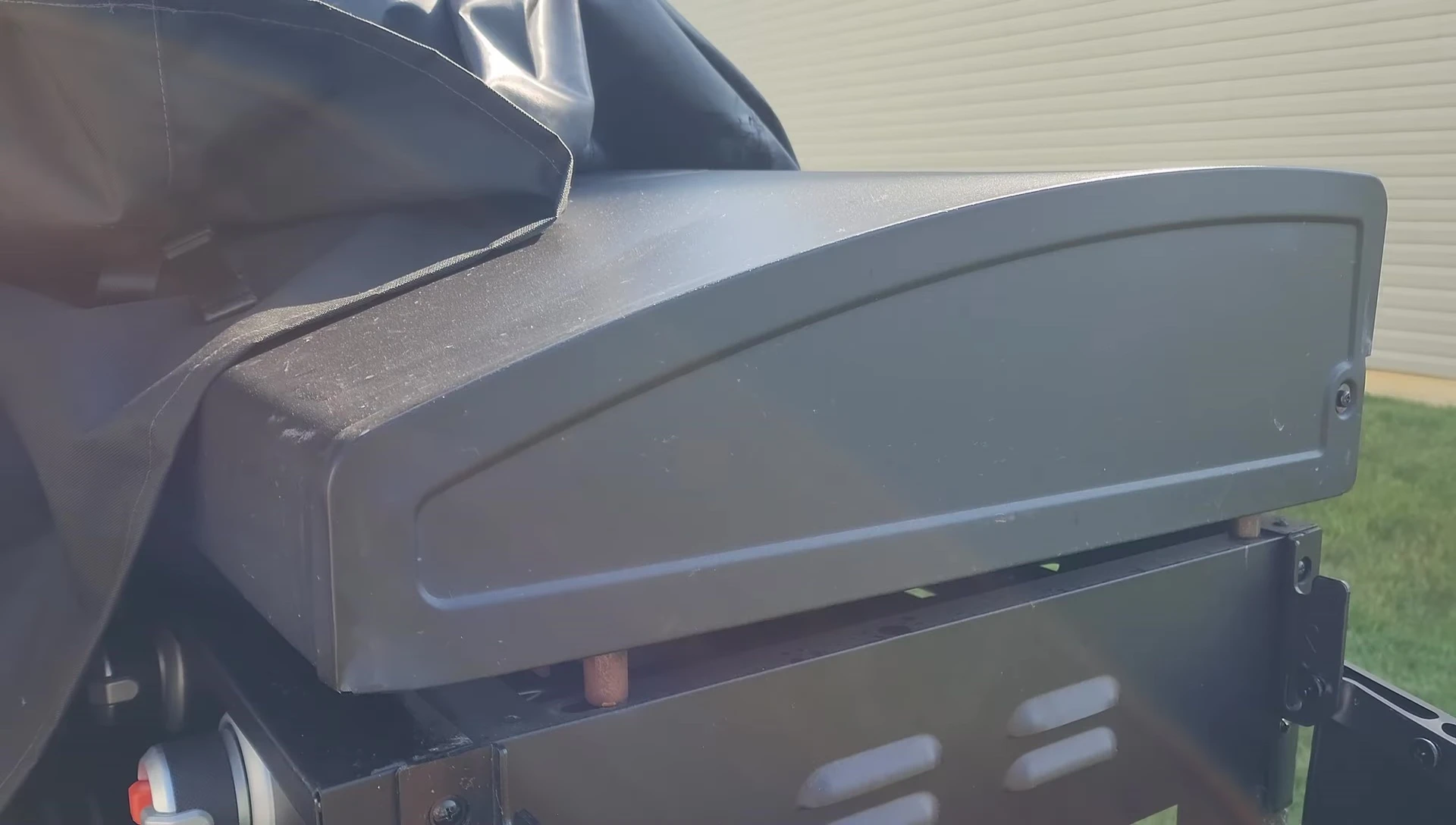 Two people struggling to lift the heavy Blackstone griddle onto its base.