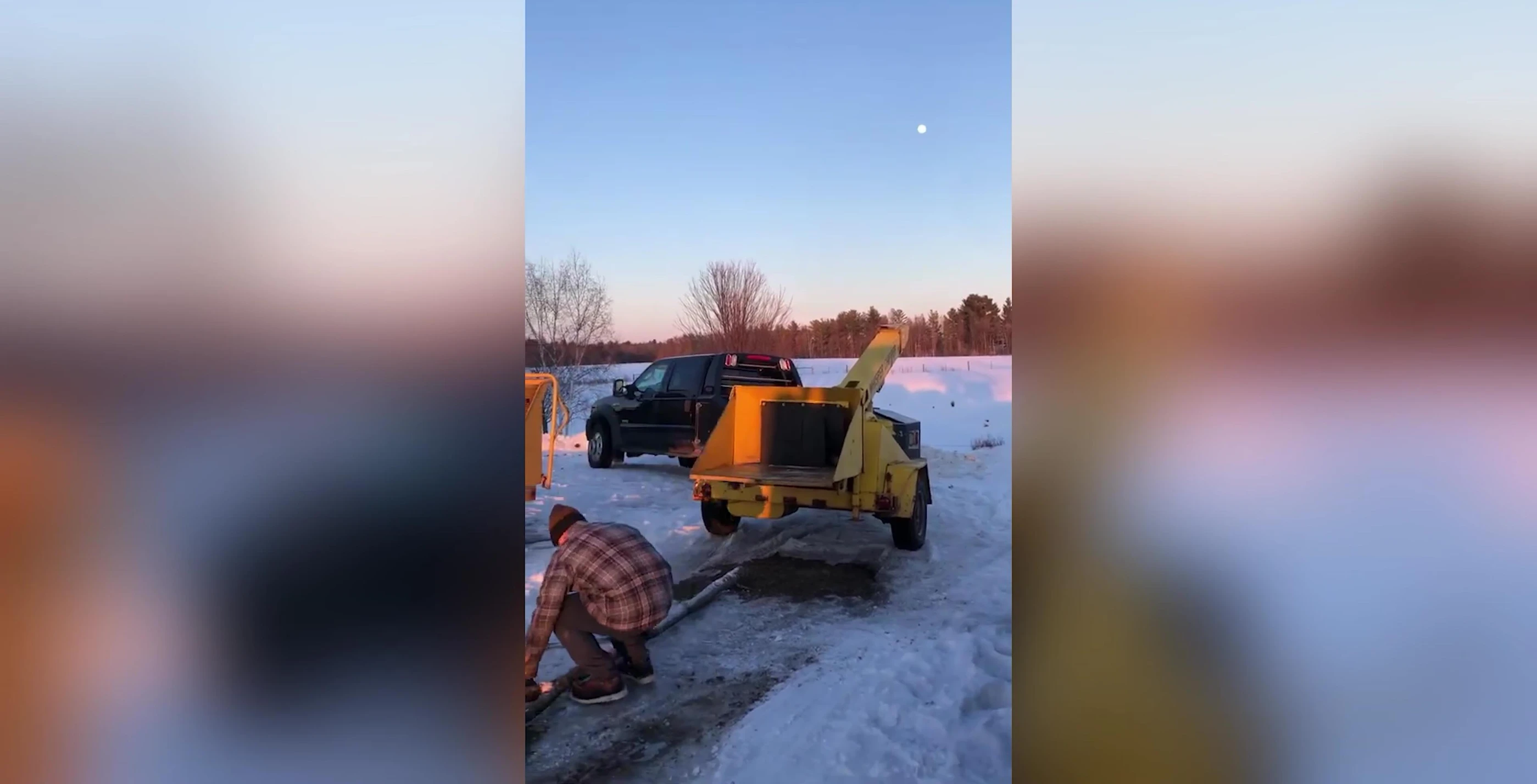 Operator working with a wood chipper in the snow