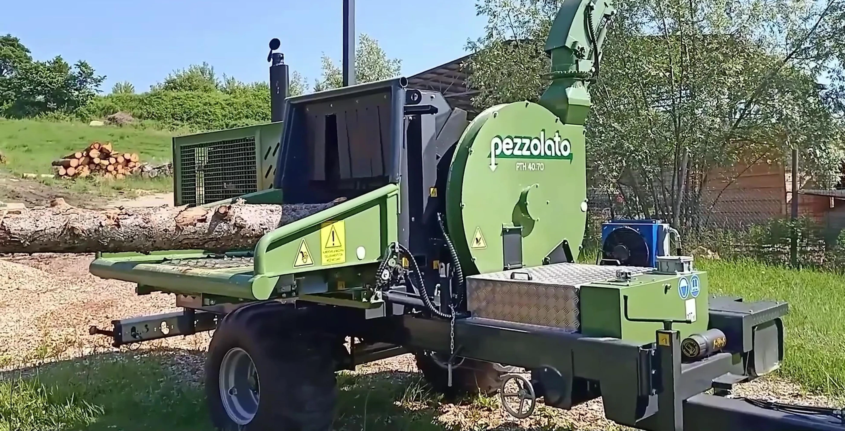 Hydraulic grapple arm of Petselato PTH 40.70M feeding logs into the chipper