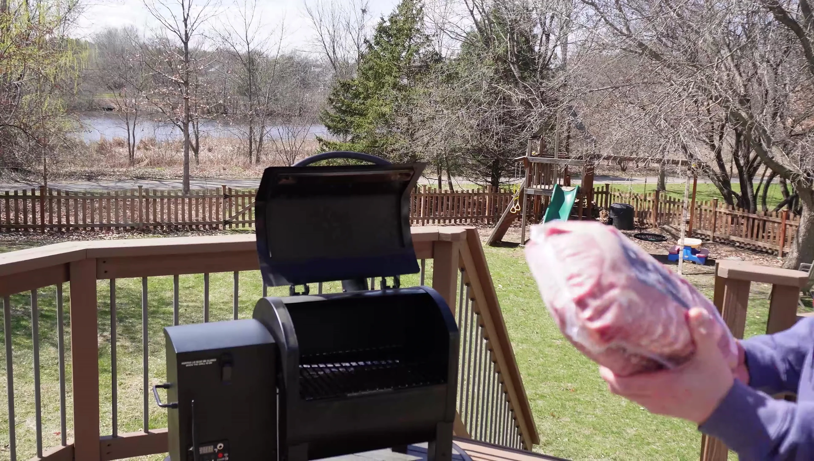 The cut rack of ribs being placed in the grill.