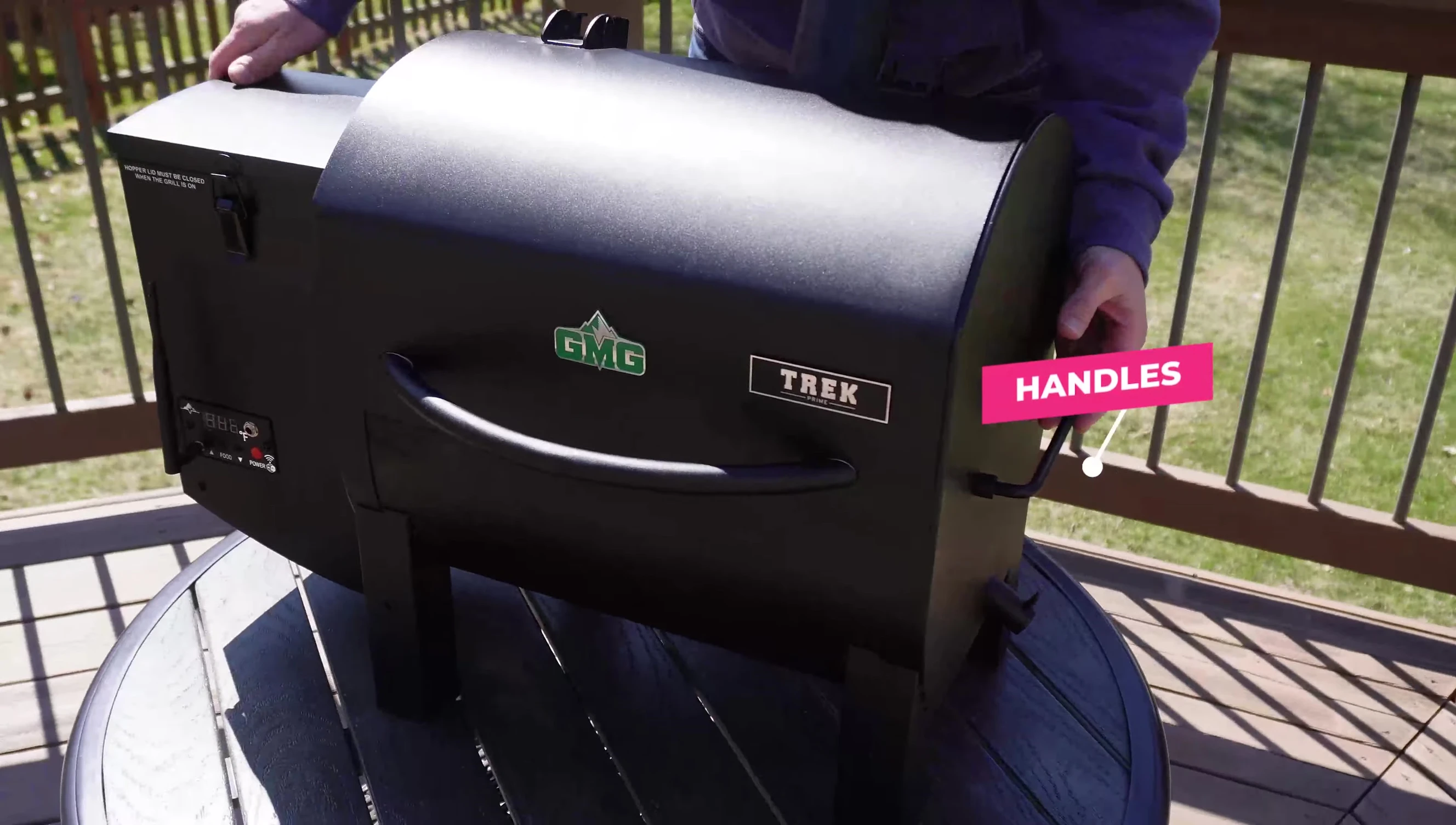 The speaker demonstrating the easy-grip dual handles on the grill.