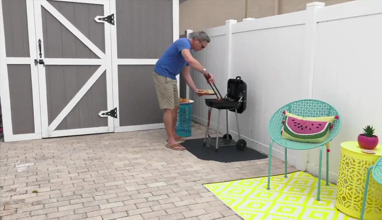 A person rolling up the GrillTex Pro grill mat.