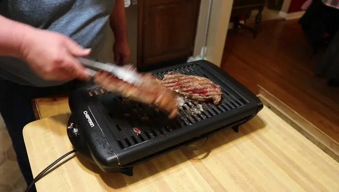 Adjust the steaks on the grill for even cooking if necessary.