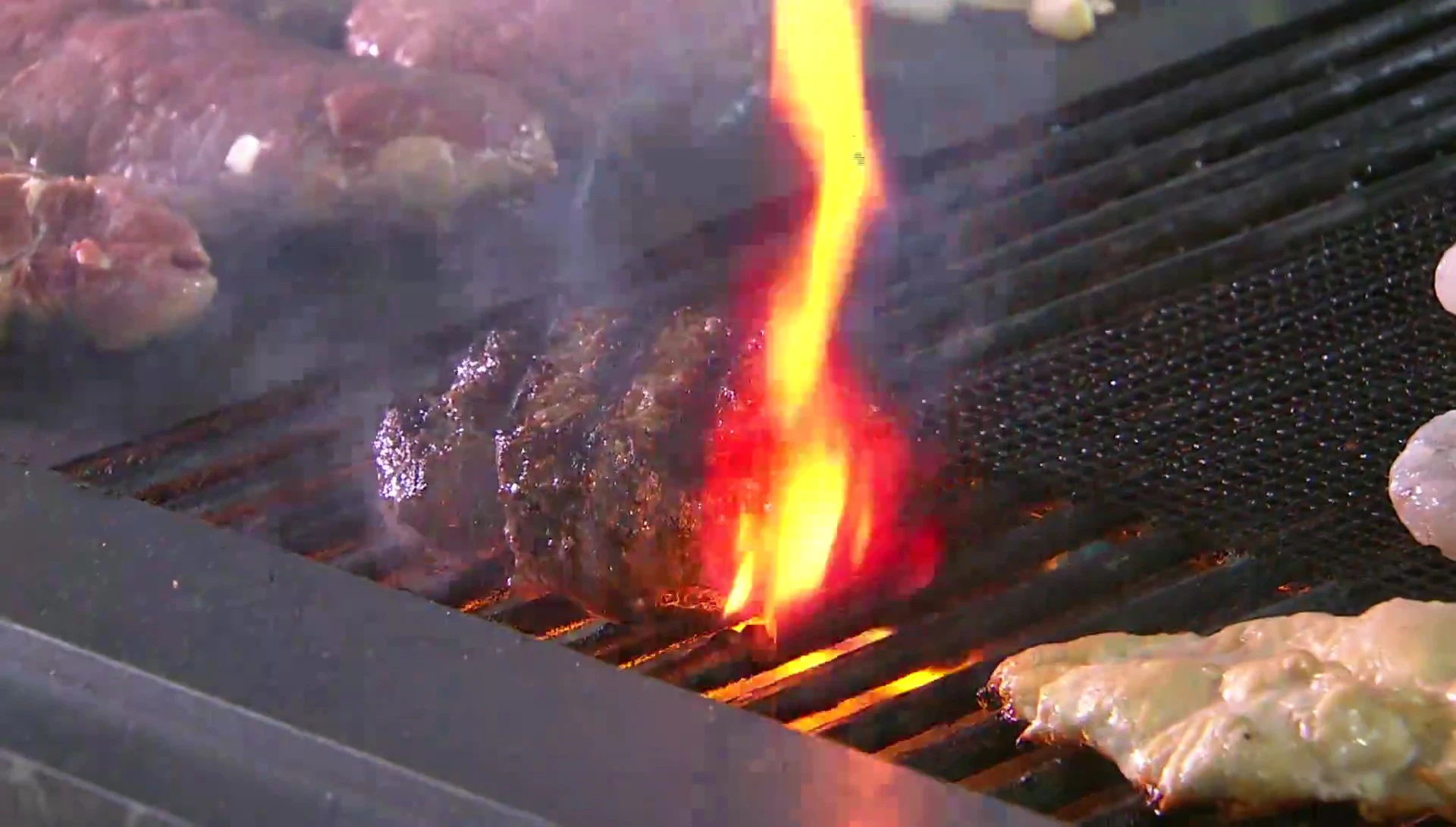 A burger cooking on the grill mat, showcasing even cooking.