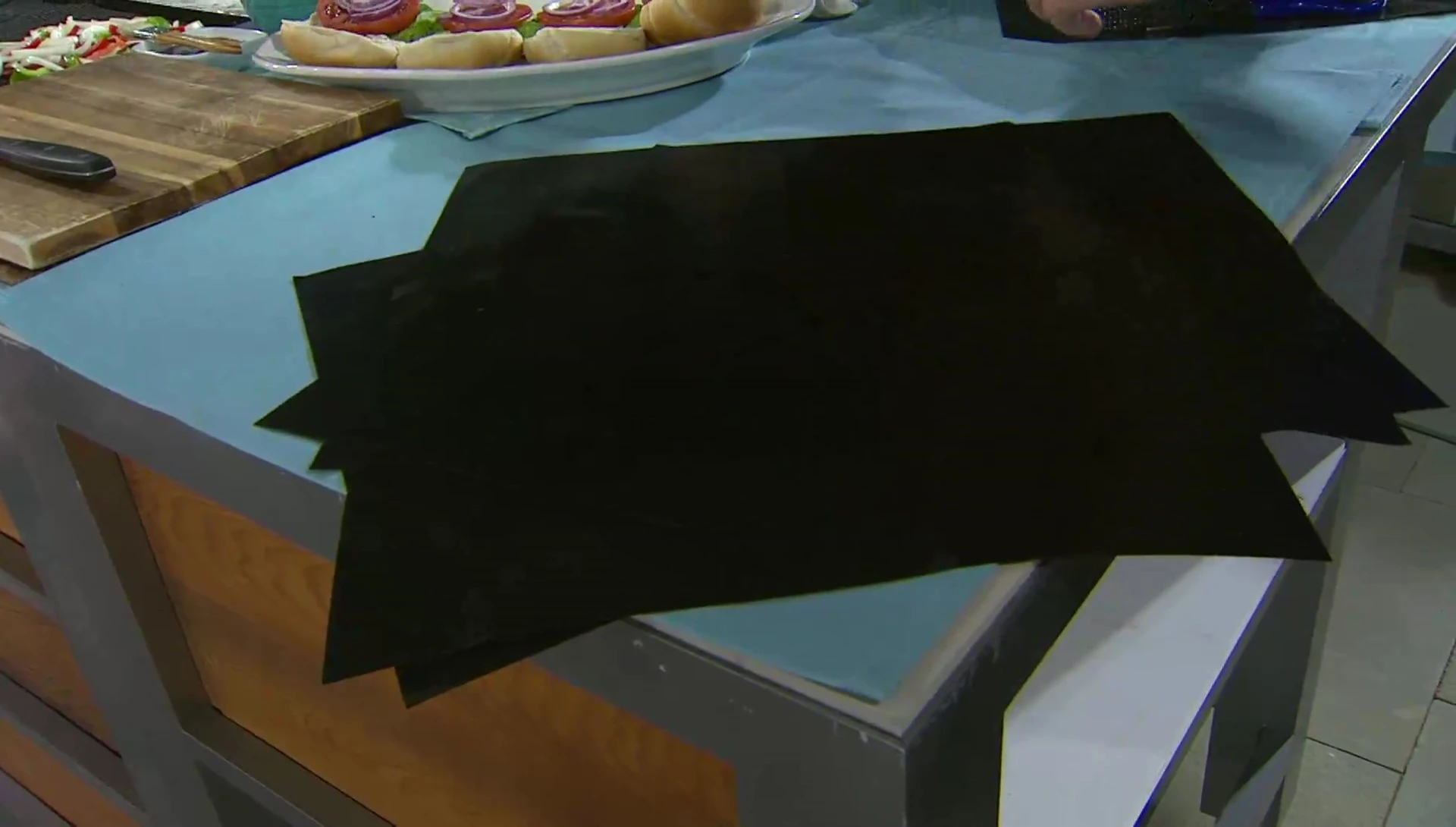 Close-up of the CooksEssentials grill mat set being unpacked and displayed.