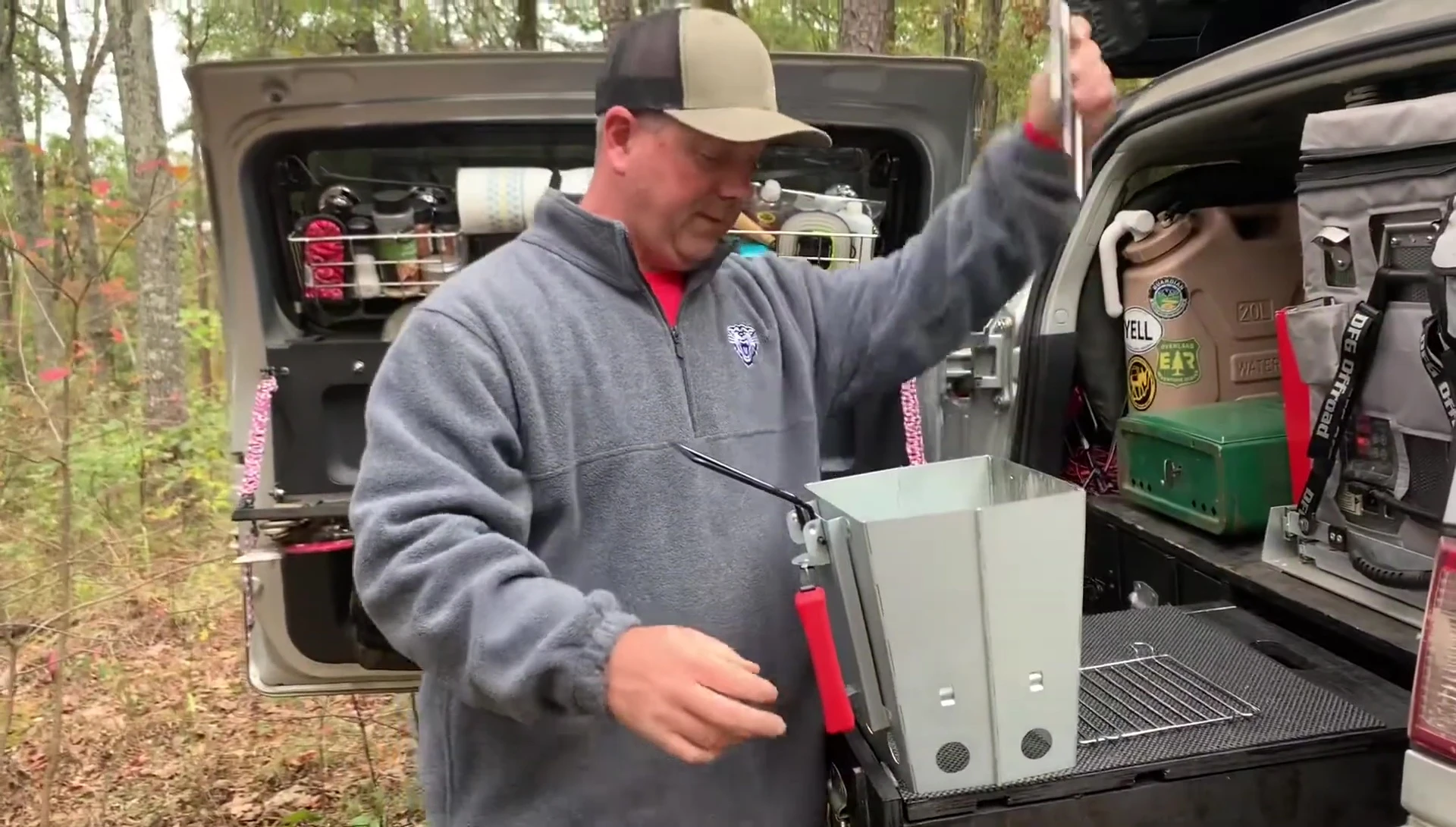 The reviewer showing how to insert the charcoal into the grill