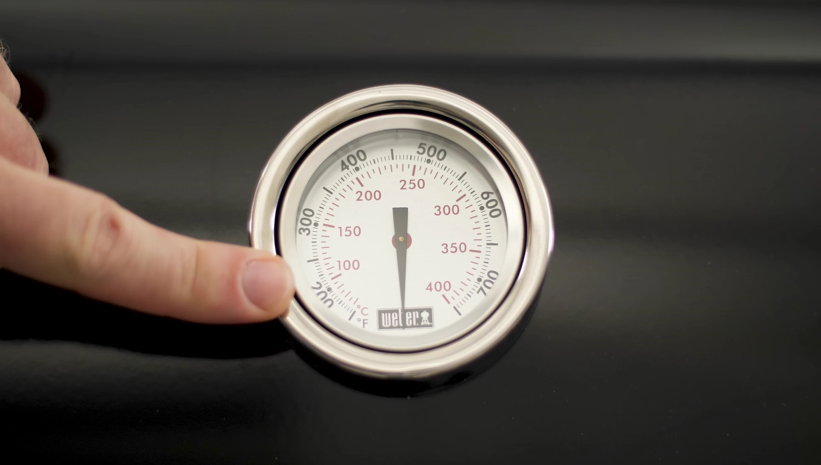 Close-up of the thermometer on the grill hood.