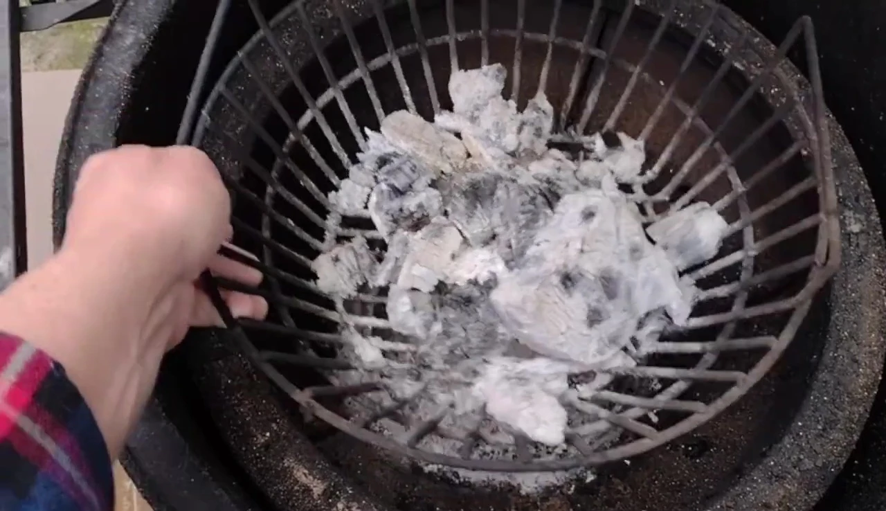 Close-up of the stainless steel ash basket, showing its initial condition.
