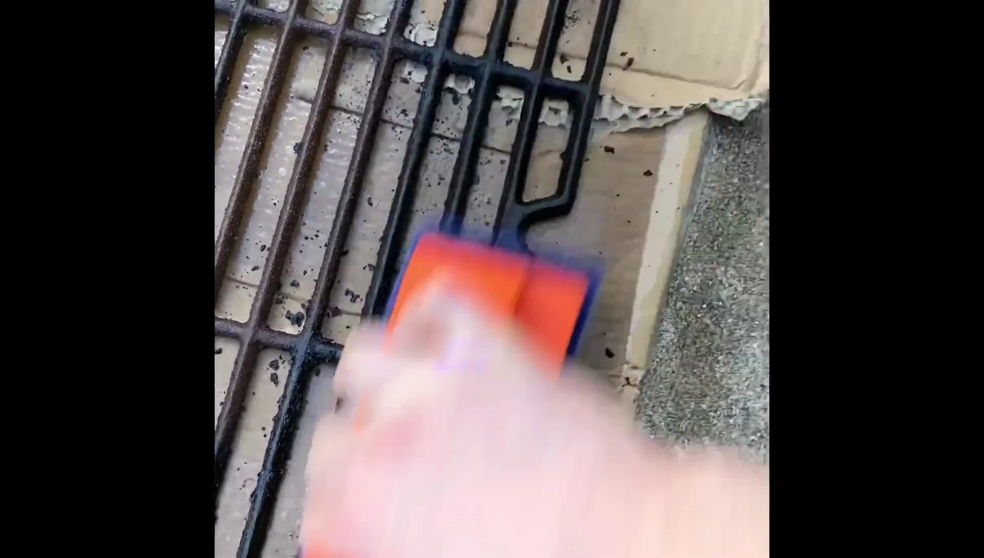 Scrubbing the grill grates with the Citrusafe scrub pad.