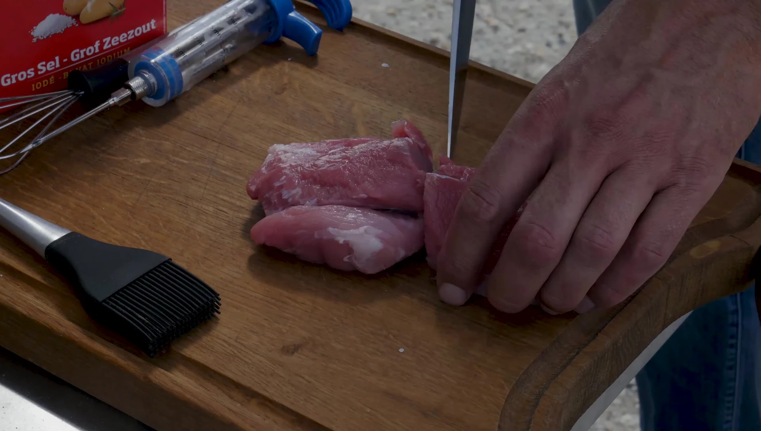 The syringe being used to inject brine into a pork loin.