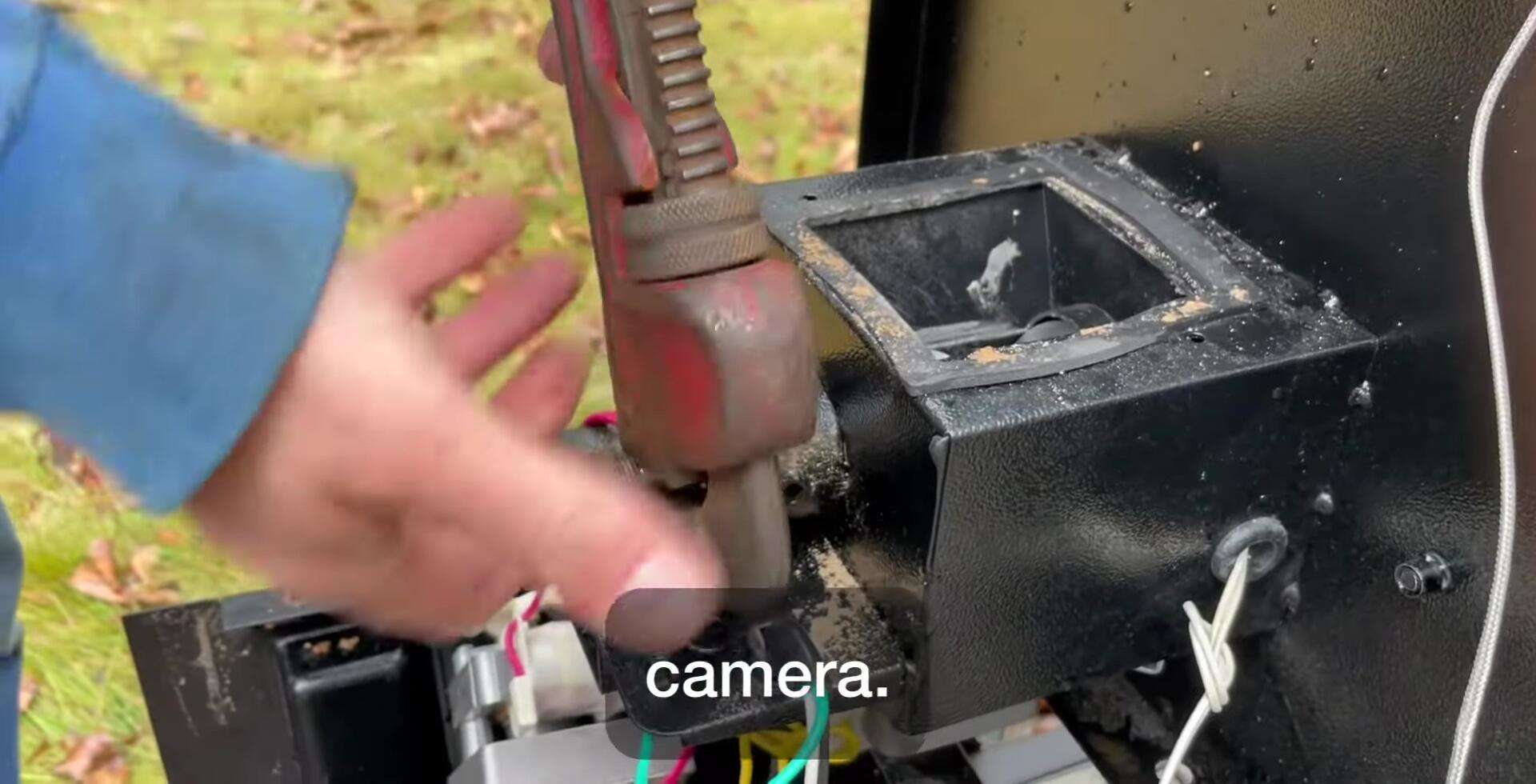 Turning the auger counter-clockwise with the pipe wrench