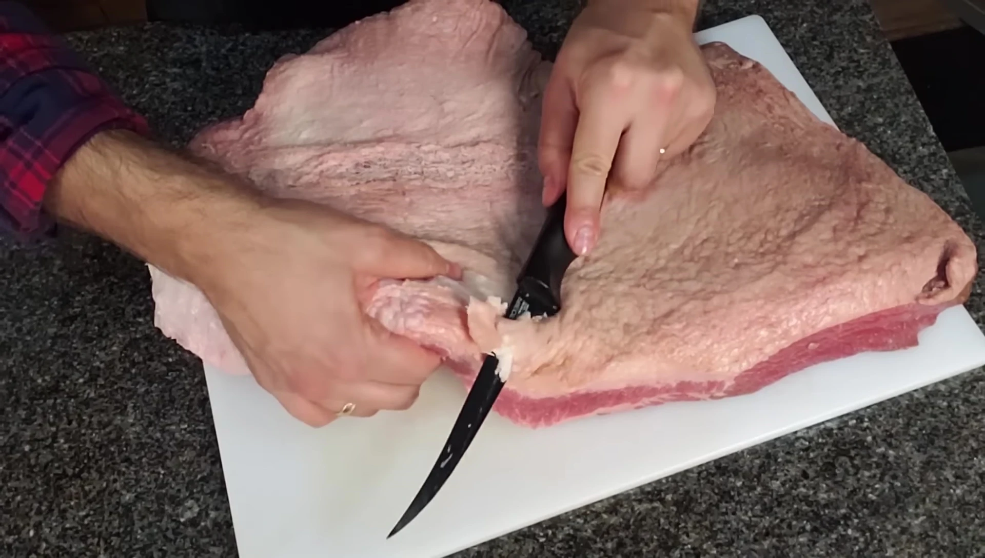 Close up of someone carefully trimming the fat cap using a sharp knife.