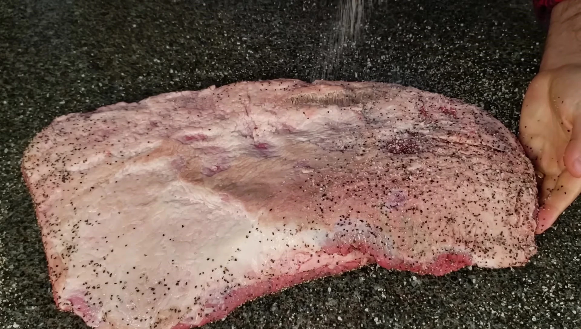 Salt and pepper being shown as the primary rub ingredients.