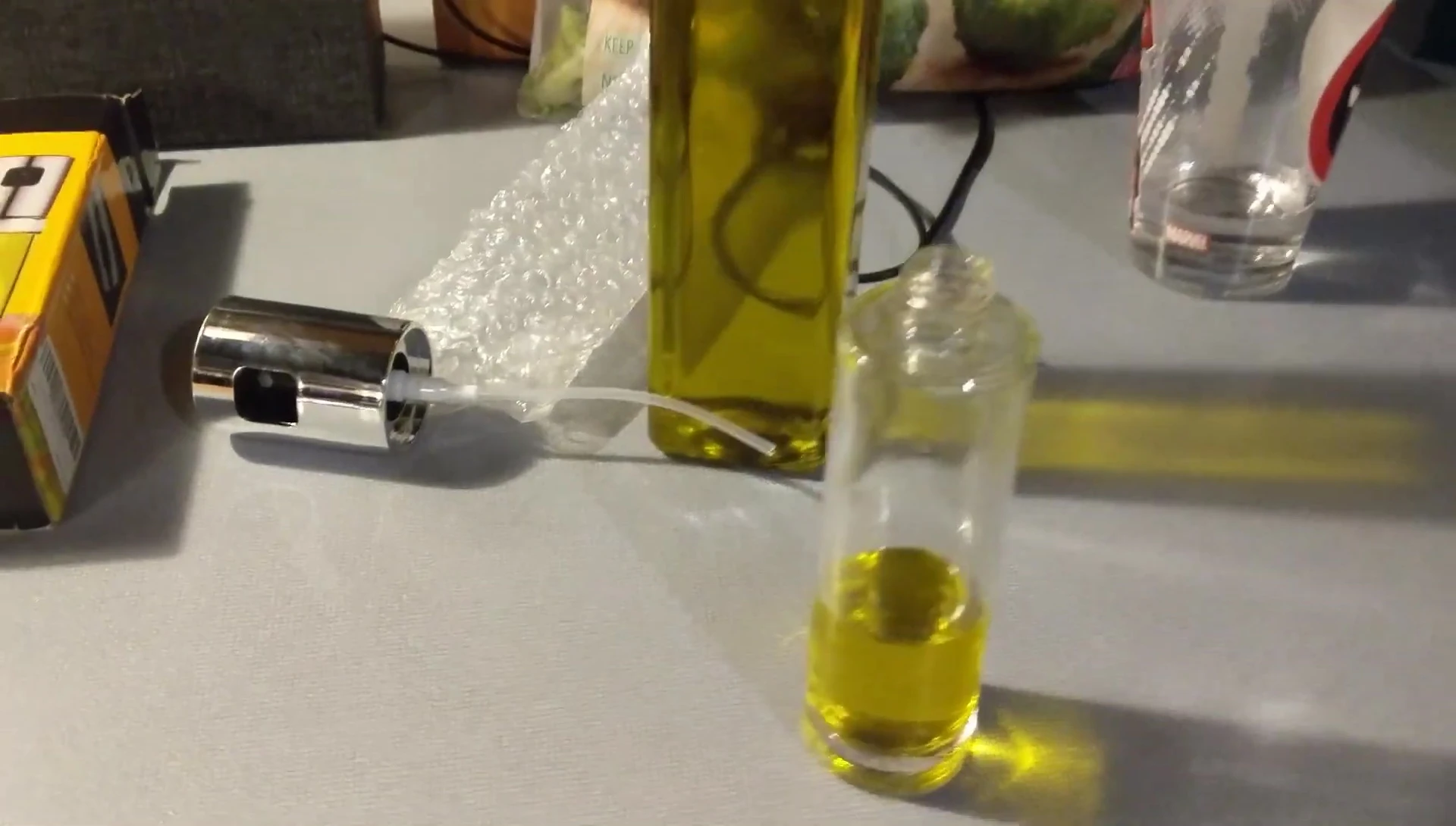 The reviewer pouring olive oil into the sprayer.