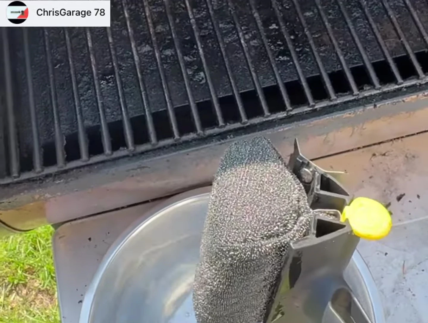 The BBQ Daddy being used to scrub a grill grate.