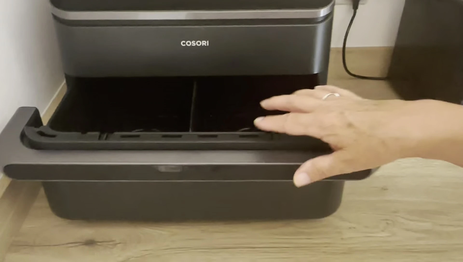The air fryer drawer open, showing the interior and divider.