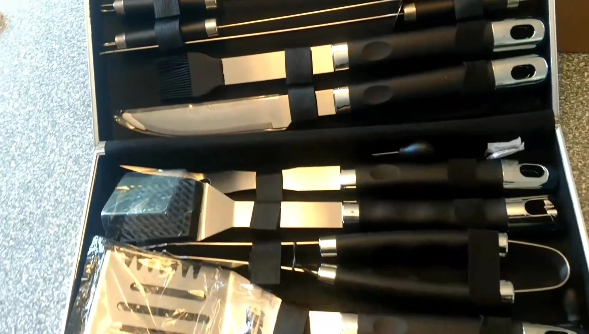 The reviewer displaying the grilling tools laid out from the case.