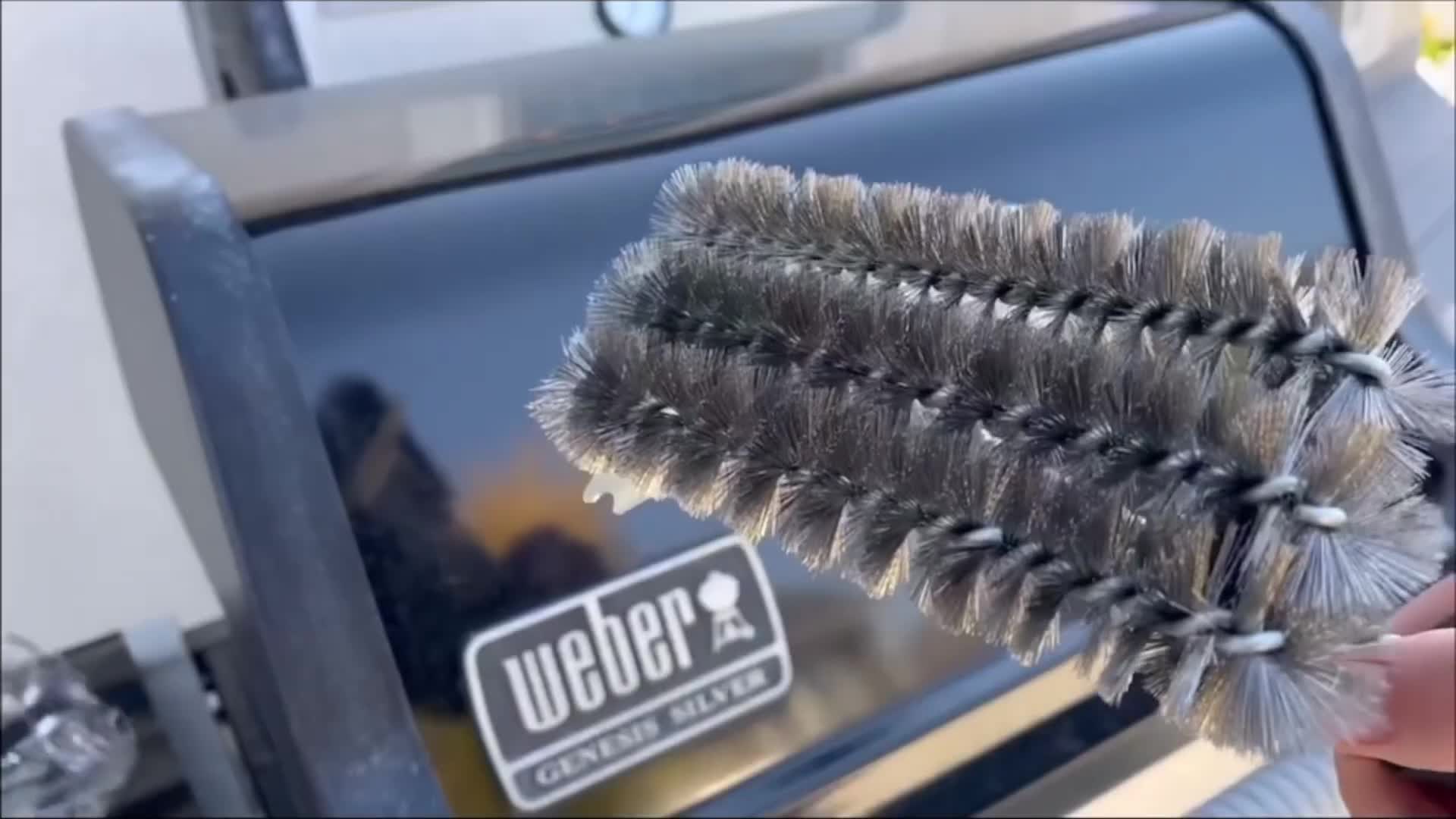 Close-up of the grill brush bristles and long handle.