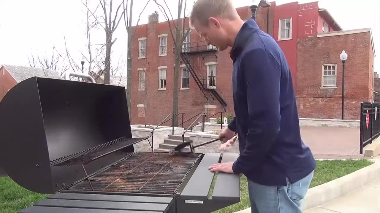 Close-up of a person visibly frustrated with a grill brush.