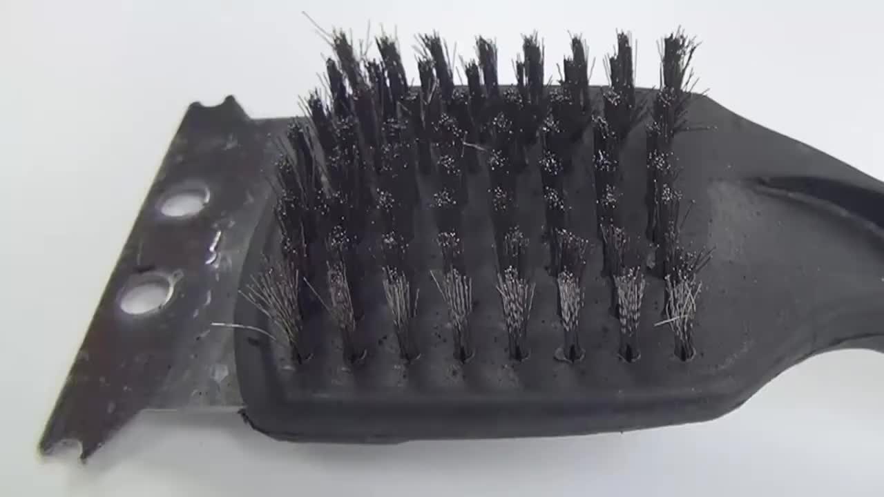 Image depicting a close-up of a worn-out, cheap grill brush with bristles falling out.