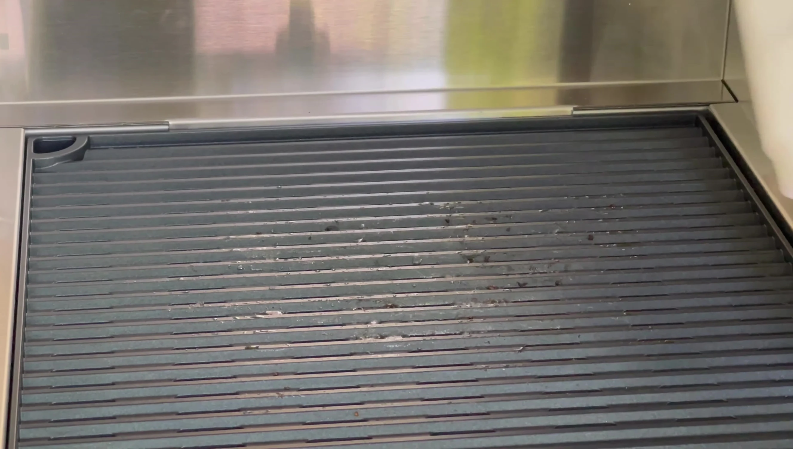 The grill surface is being wiped clean after use.