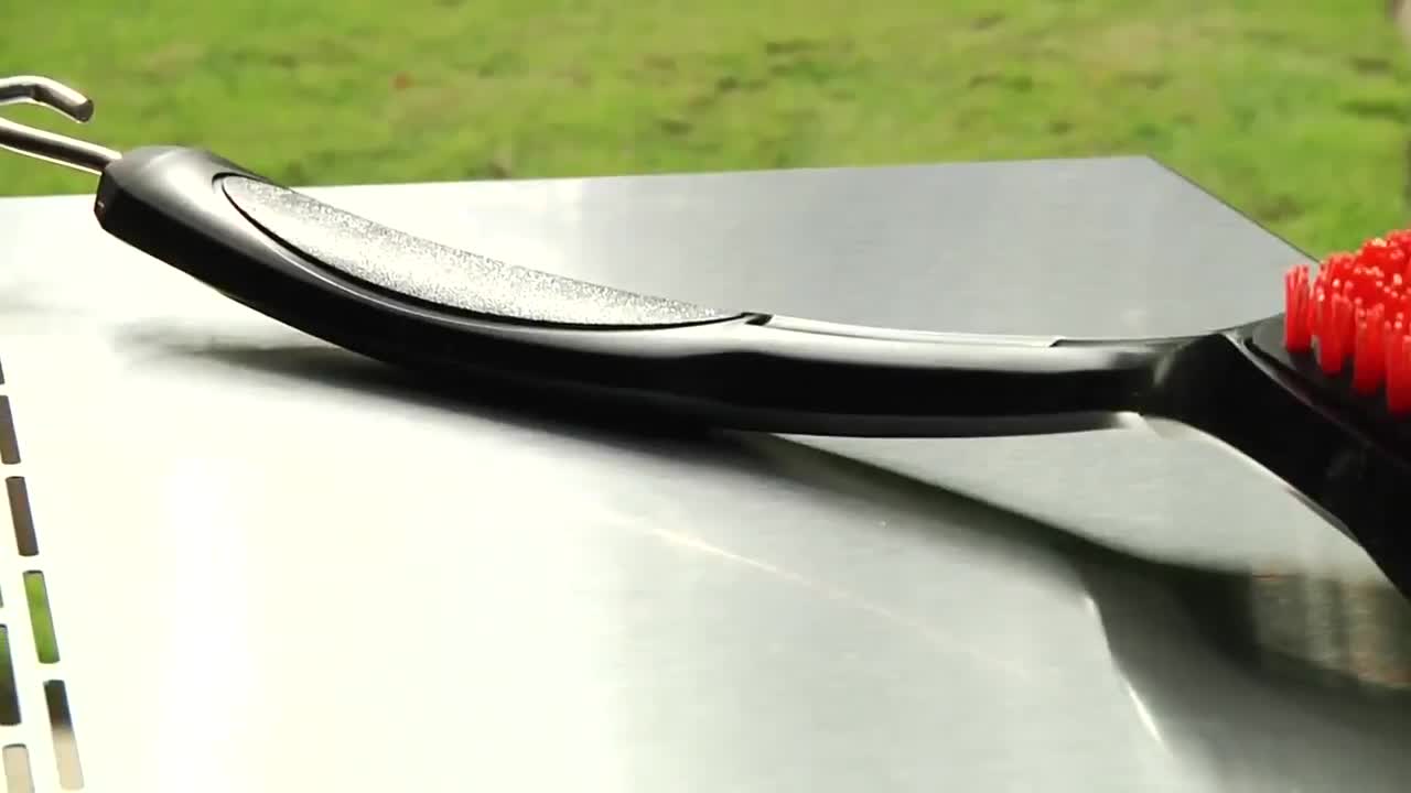 Close-up of the nylon bristle brush cleaning grill grates.