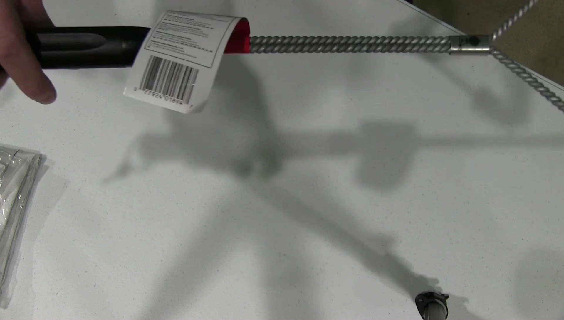 The reviewer holding the grill brush, demonstrating the flexibility and feel of the handle.