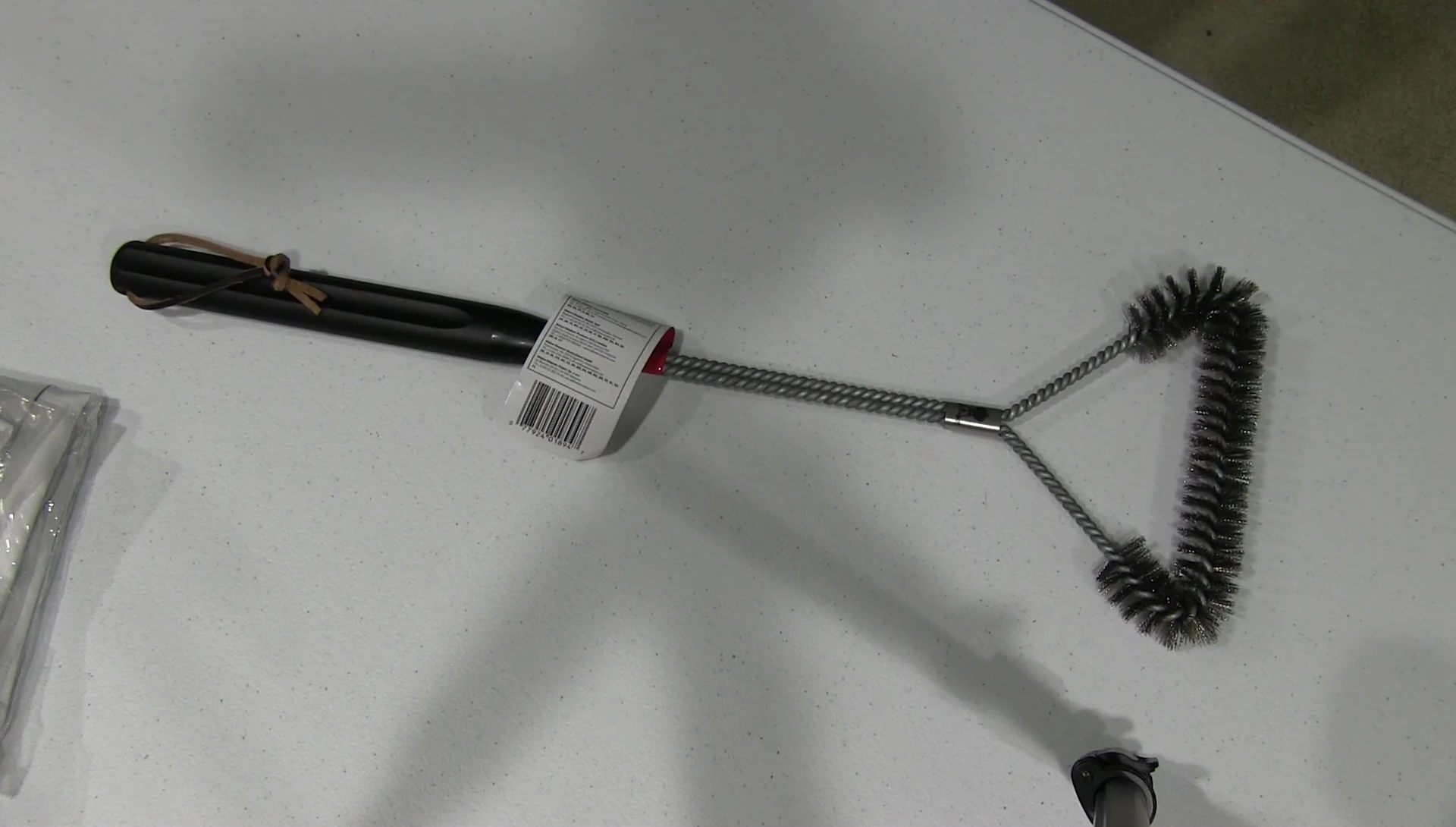 The reviewer holding the grill brush, expressing satisfaction with the product.