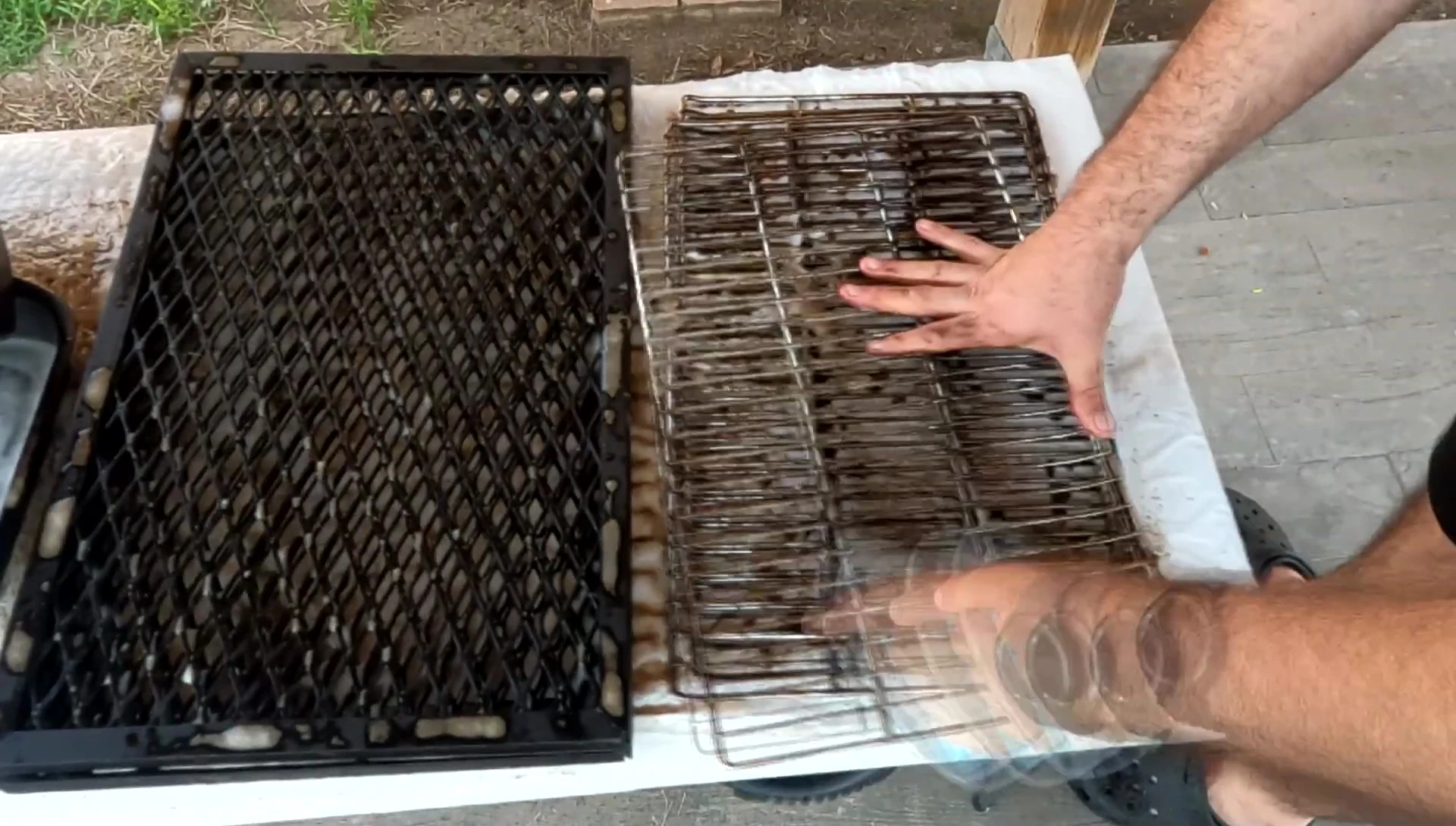 The reviewer using the brush to scrub a grate