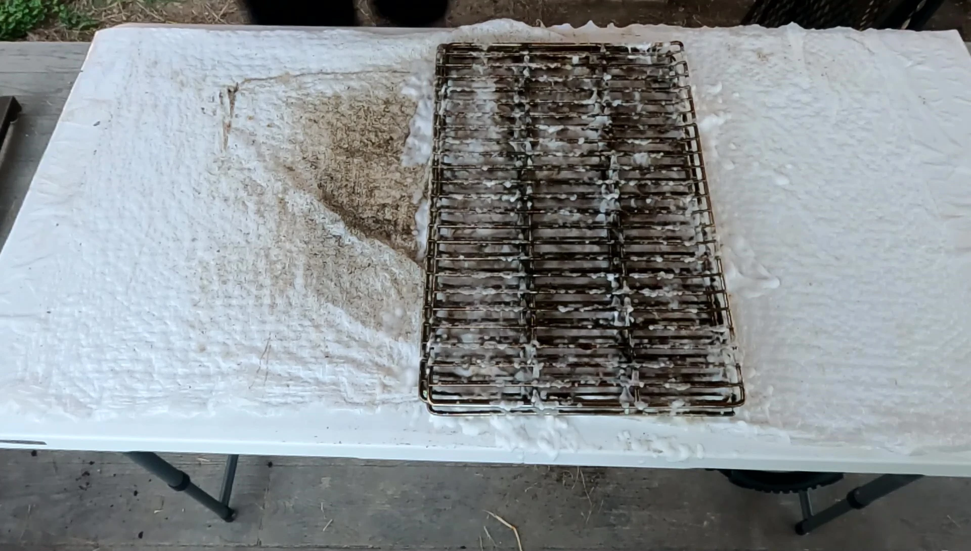 The reviewer applying the cleaner liberally to one of the grates