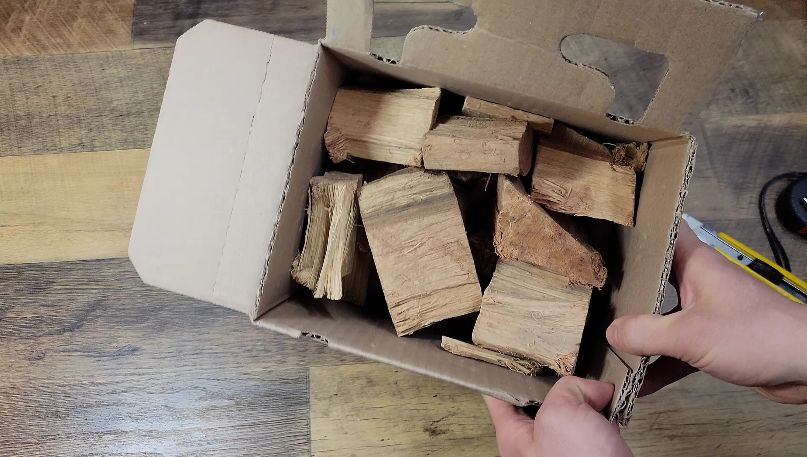 The reviewer showing the wood chunks in the box.