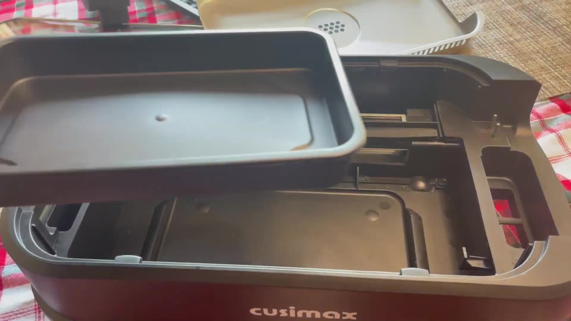 Adding the water tray to the base of the CUSIMAX smokeless grill.