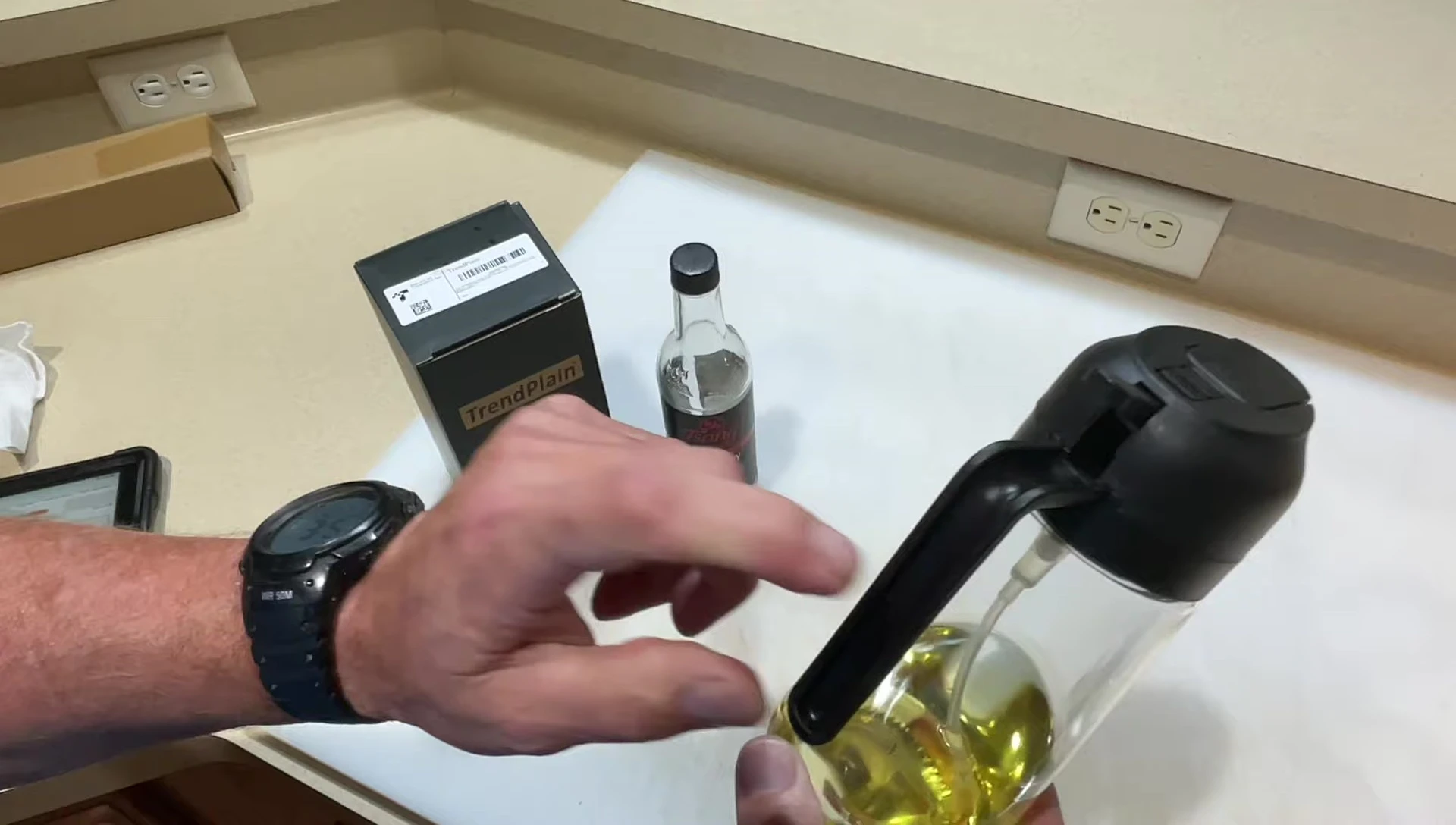 Hand holding the sprayer, highlighting the plastic handle and pour spout