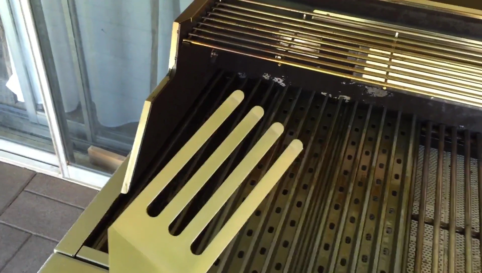 Demonstration of using the Grill Grates cleaning tool.