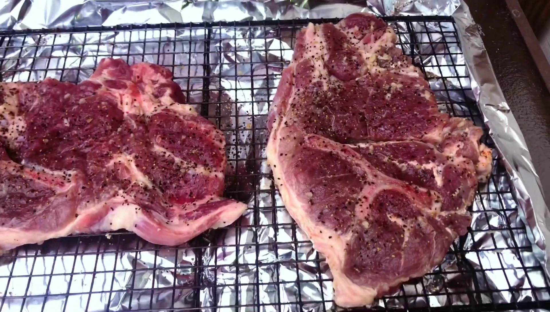Seasoned pork steaks ready for grilling.